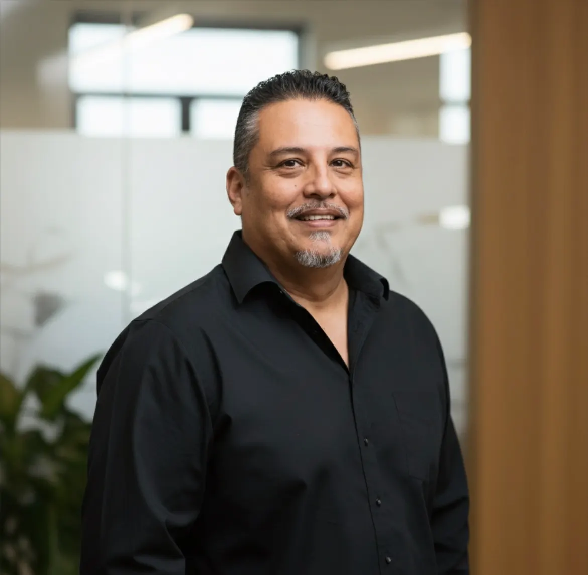 Milo Salazar, owner of CPR Roof Repair, smiling in a professional office setting